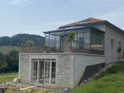 VERANDA SUR MESURE - UNE HARMONIE ENTRE L’ACIER ET LA PIERRE LOCALE