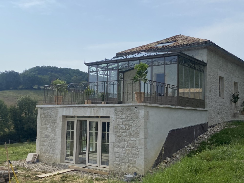 VERANDA SUR MESURE - UNE HARMONIE ENTRE L’ACIER ET LA PIERRE LOCALE